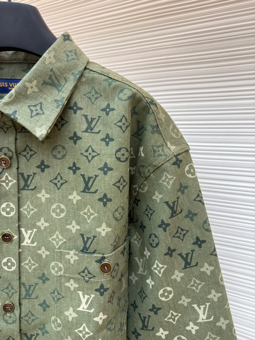 LOUIS VUITTON work jacket-style shirt with full lapel print ●Original version: Purchased and developed for 16,000 ●Item number: 1681953-B50 ●Fabric: denim fabric ●Technology: Printing ●Color: green ●Version: fitted version ●Weight: about 770 grams ●Size: S-M-L-XL ●Description: This LV lapel all-printed work jacket-style shirt adopts positioning cutting technology: before cutting the fabric pieces, the position of the all-printed Monogram pattern is locked through digital typesetting to ensure that the pattern is continuous and without misalignment after splicing, and the pattern alignment error between the body and the solid color splicing area is controlled within 0.5cm. The printing process uses digital direct injection technology: the pigment penetrates the fabric fibers with micron-sized particles, presenting a low-saturation vintage tone while maintaining the breathability of the fabric. The wear resistance of the printing layer reaches level 5 (friction test ≥ 200 times without falling off). The body is made of twill canvas blended fabric, and the splicing parts are reinforced with double-needle buried clip technology. The buttons are made of brass-plated matte paint, and the stitching is made of high-tenacity nylon thread with a tensile strength of 150N. The overall process takes into account both visual integrity and practical durability. The overall wiring is straight and delicate, the fabric is comfortable and soft, and the color is consistent without color difference. It can be matched with the same style to create a fashionable look and control various occasions. Customized accessories, complete with three standards, same style for men and women!